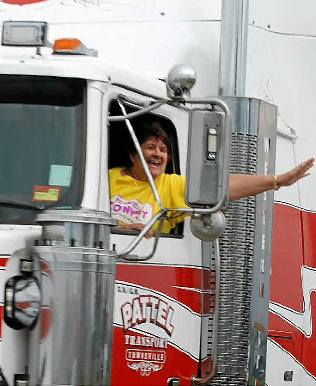 ALL SMILES: A passenger in a truck waves during convoy. ALL SMILES: A passenger in a truck waves during convoy.